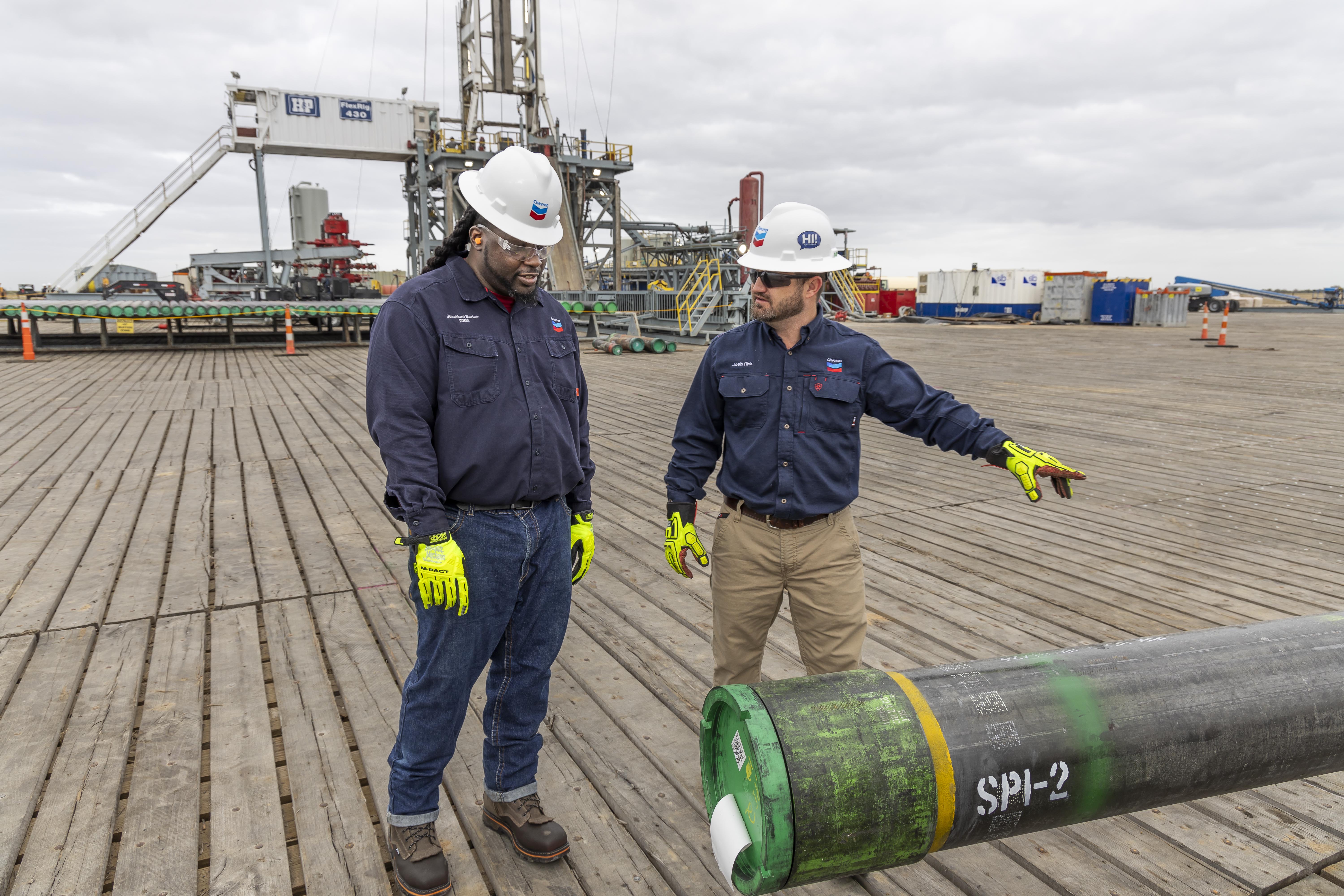 A pair of workers talking through a task.