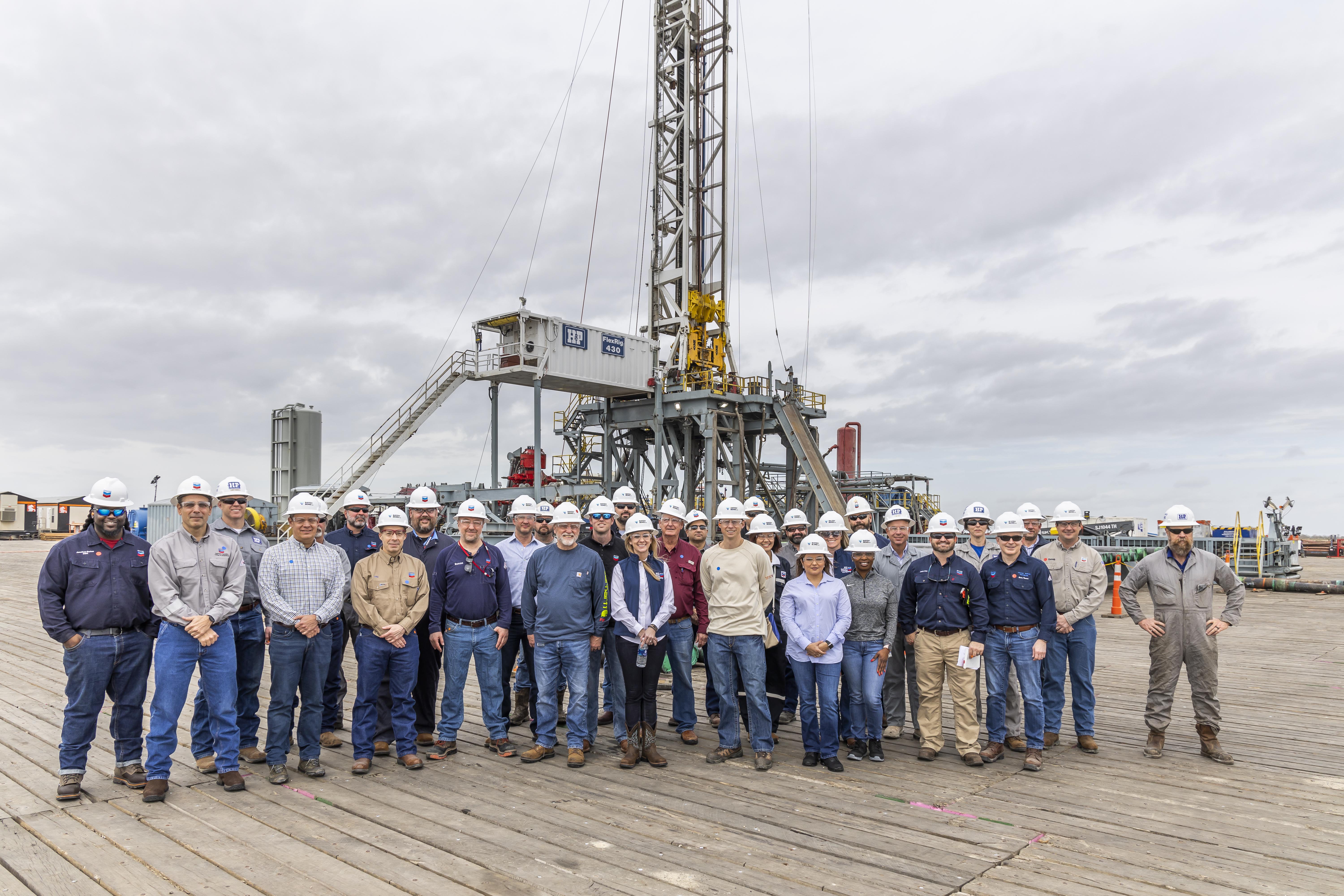 A group of workers pose proudly at their work site.